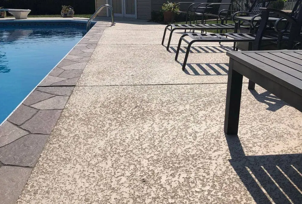 Clean back patio and poolside concrete surface at a residential home