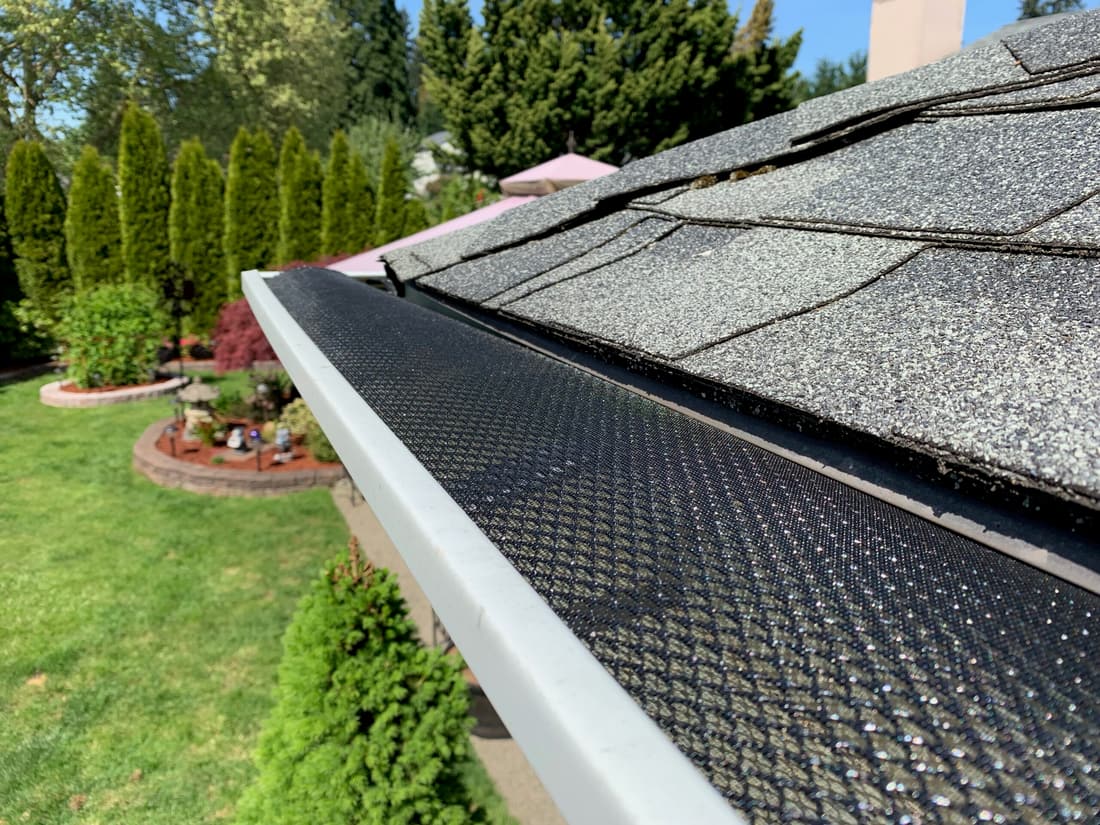 Black gutter mesh guard fitted along a home's gutter line