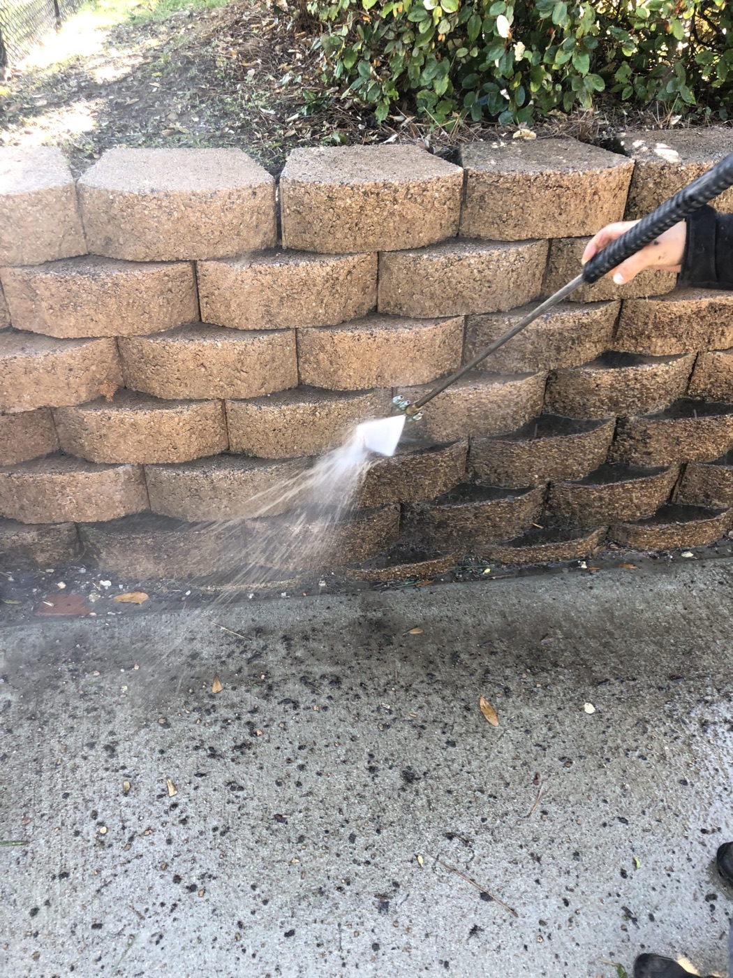 Pressure washing a stone retaining wall